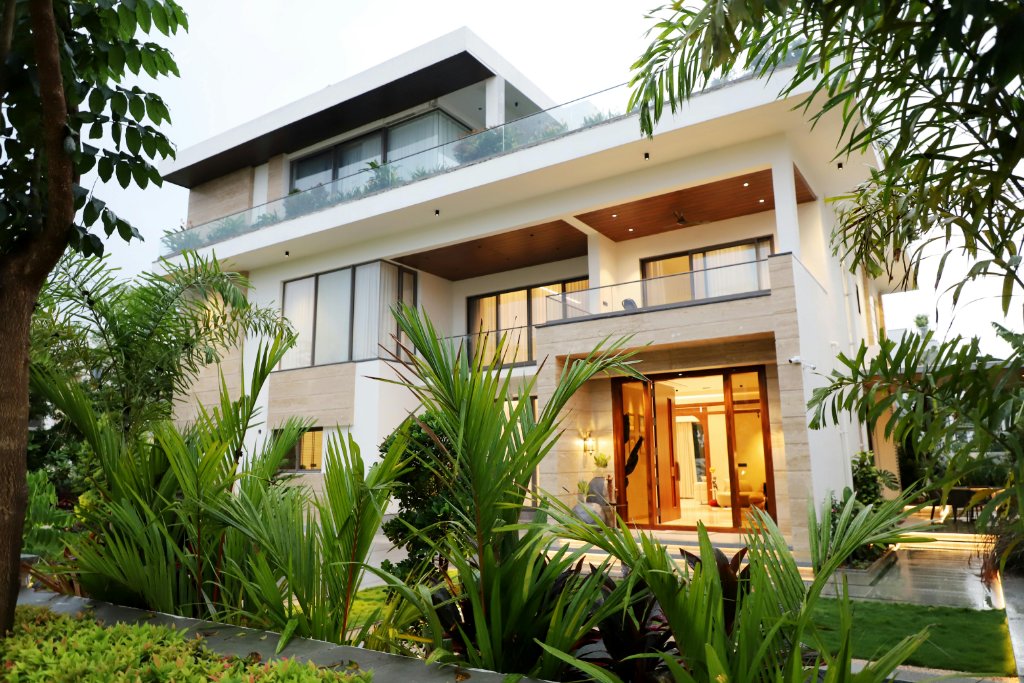 A modern home behind tropical landscaping