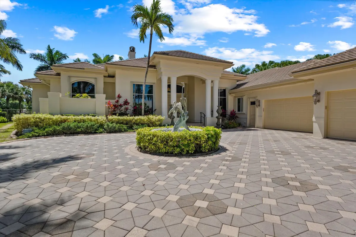 Exterior Front w/ 4 car garage at 1648 Cypress Row Drive, West Palm Beach