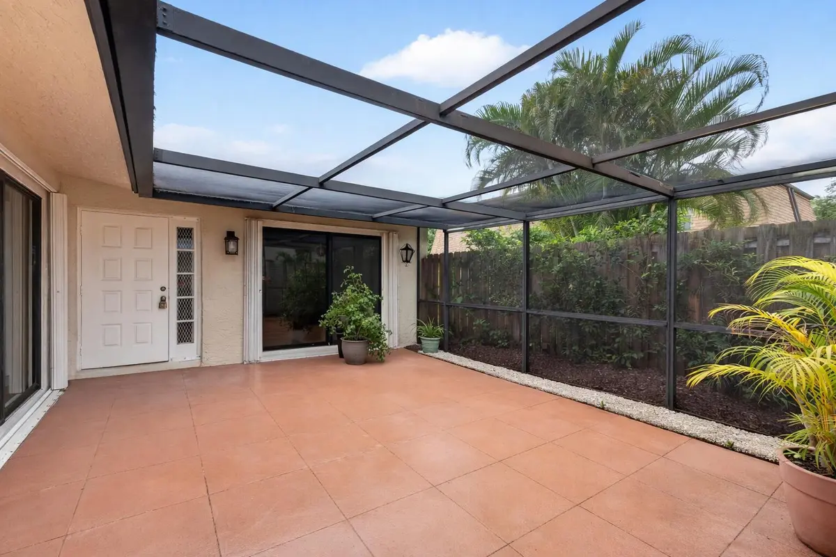 Sunny screened patio with plants at 801 NW 30th Avenue C, Delray Beach