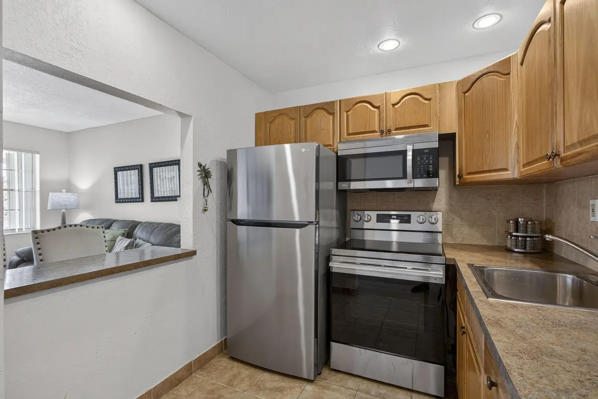 Opening through kitchen to living area, at 181 Bedford G, West Palm Beach