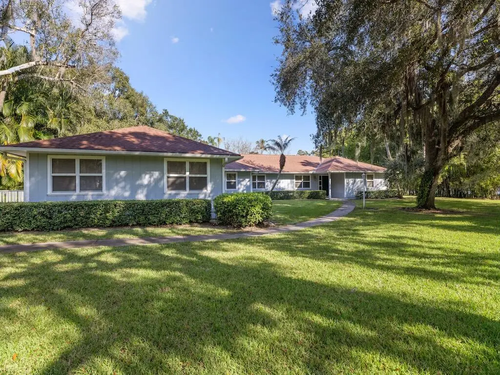 Front view with mature Oaks at 4790 16th Street, Vero Beach
