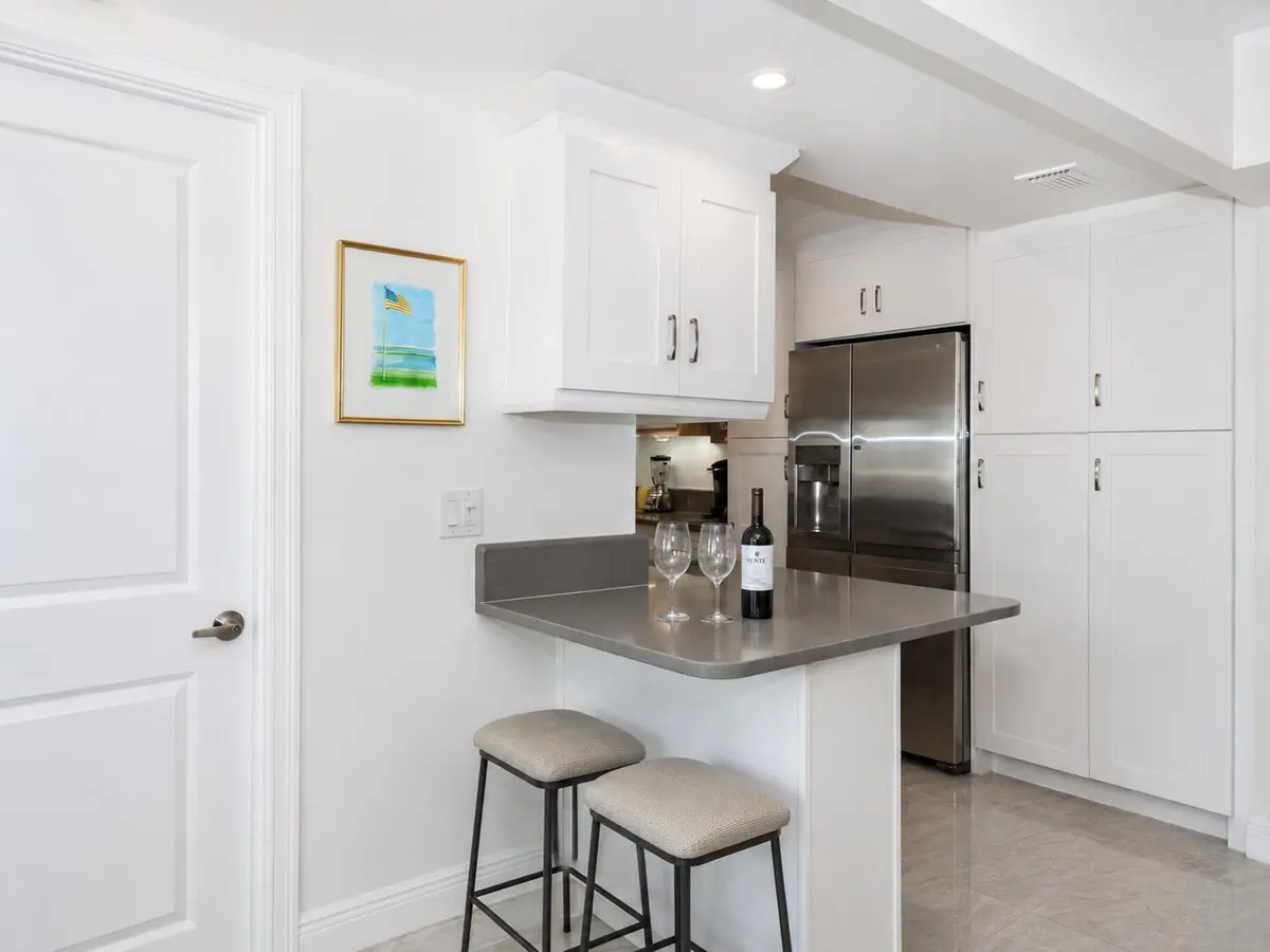 723 kitchen with bar stools at 3450 S Ocean Boulevard 7230, Palm Beach