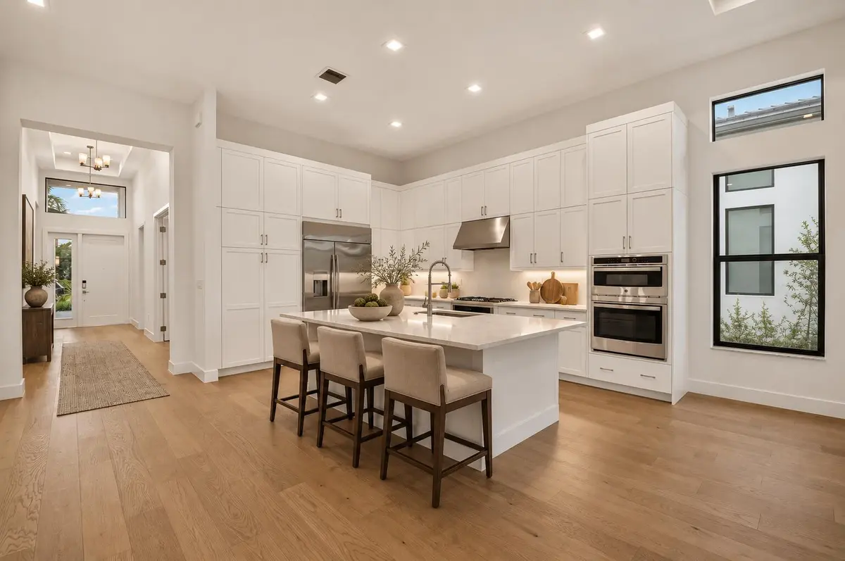 Warm taupe kitchen with dark oak stools- at 9724 Juniper Bay Avenue, Boca Raton