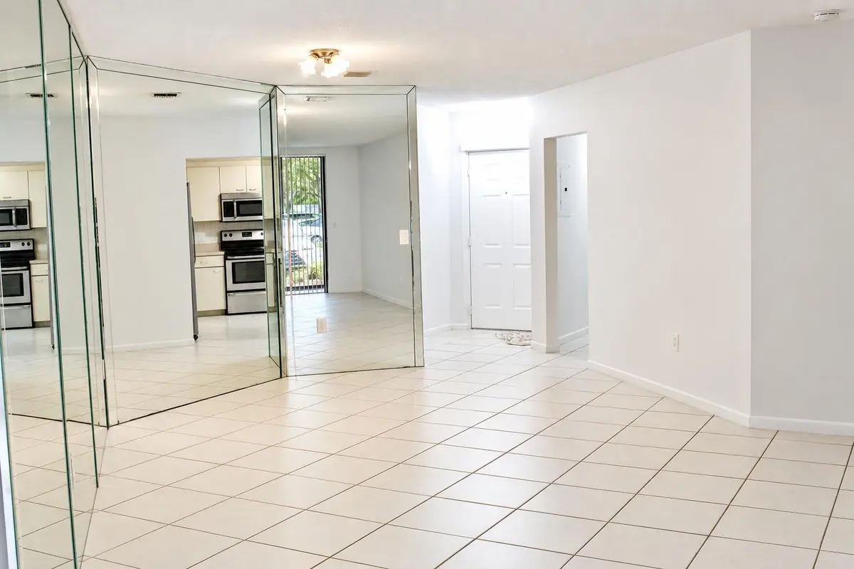 Bright Mirrored Foyer and Kitchen View at 4450 NW 30TH Street 111, Coconut Creek