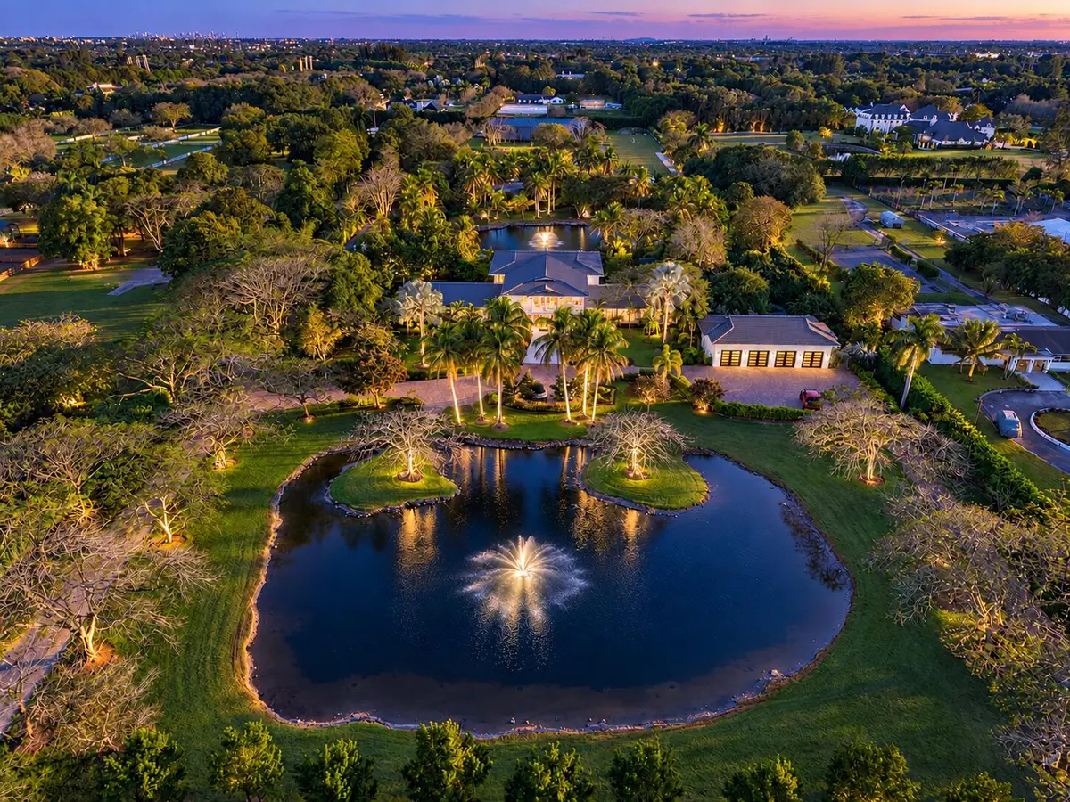 Twilight estate with fountains and trees at 13920 Stirling Road, Southwest Ranches