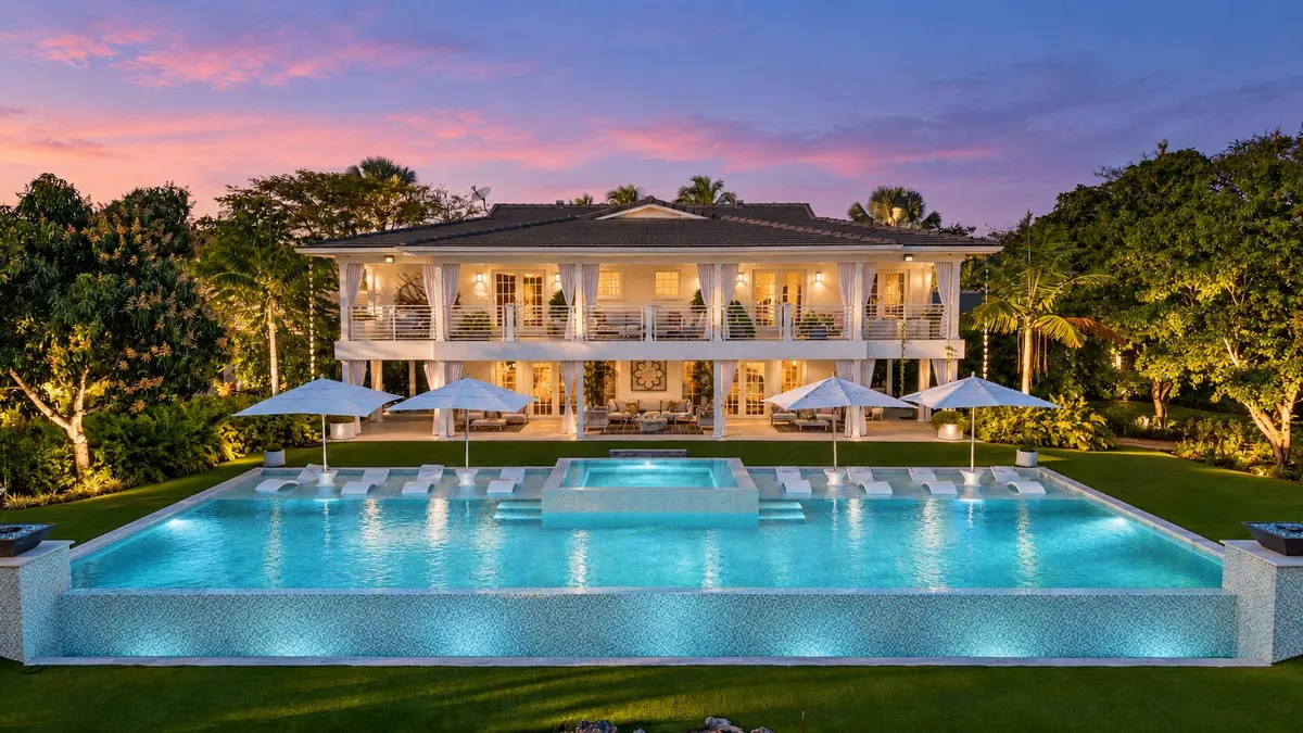 Twilight luxury home with glowing infini at 13920 Stirling Road, Southwest Ranches