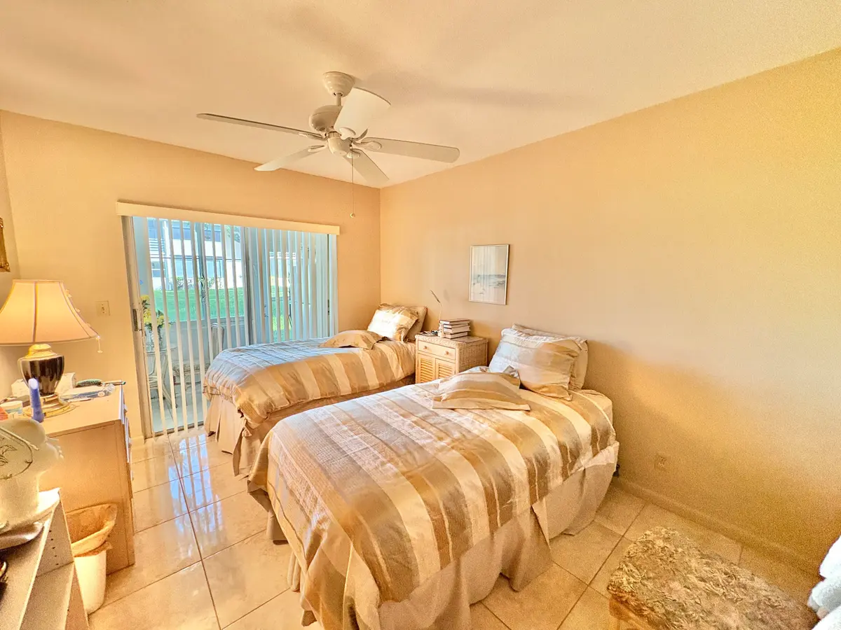sliders to sunroom from bedroom at 49 Norwich C, West Palm Beach