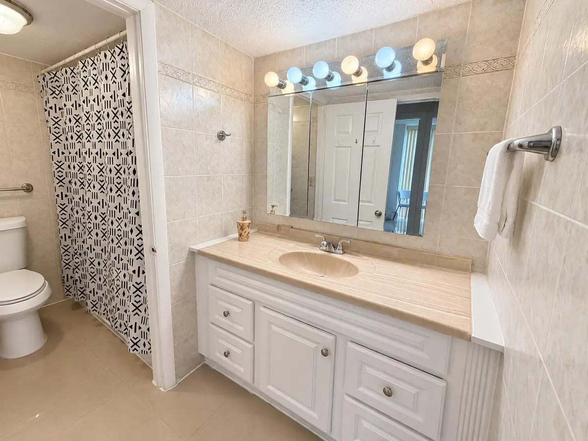 Baño beige renovado con espejo iluminad at 17021 N BAY Road 107, Sunny Isles Beach