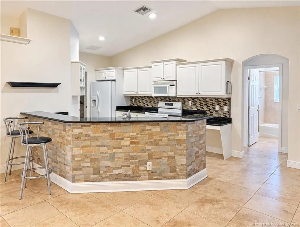 Breakfast bar and kitchen toward laundry at 446 NE Vanda Terrado, Jensen Beach