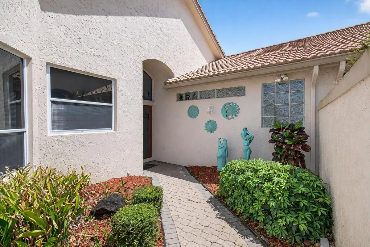 Inviting entrance with tropical decor at 8864 Shoal Creek Lane, Boynton Beach