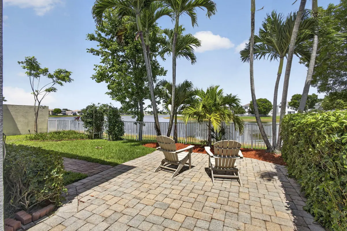 Fenced backyard with lake views at 214 Berenger Walk, Royal Palm Beach