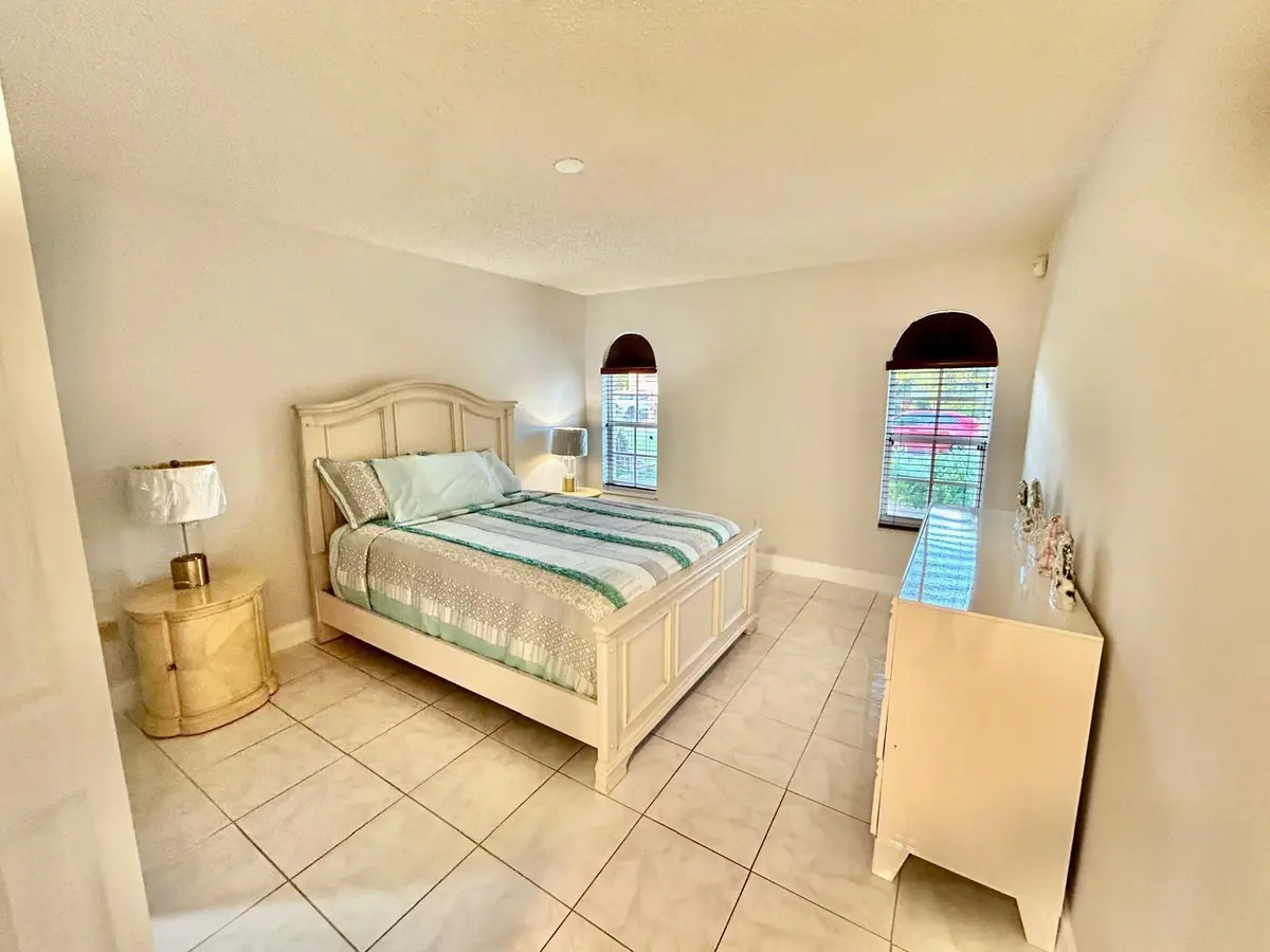 Master bedroom with white bed at 7526 SW 7th Court, North Lauderdale