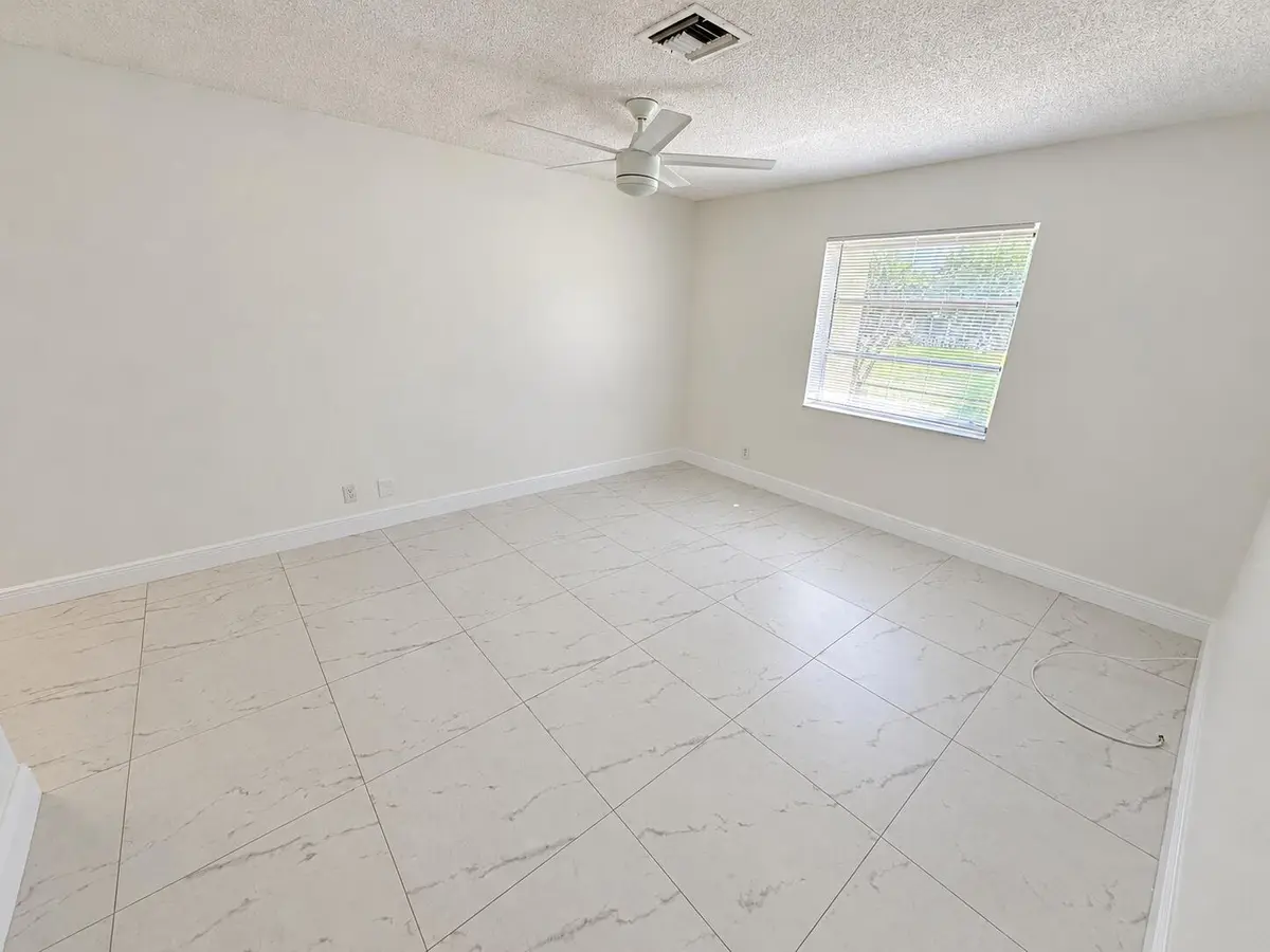 Bright Empty Room with Ceiling Fan at 1120 LEMON TREE Terrace 73-C, Delray Beach