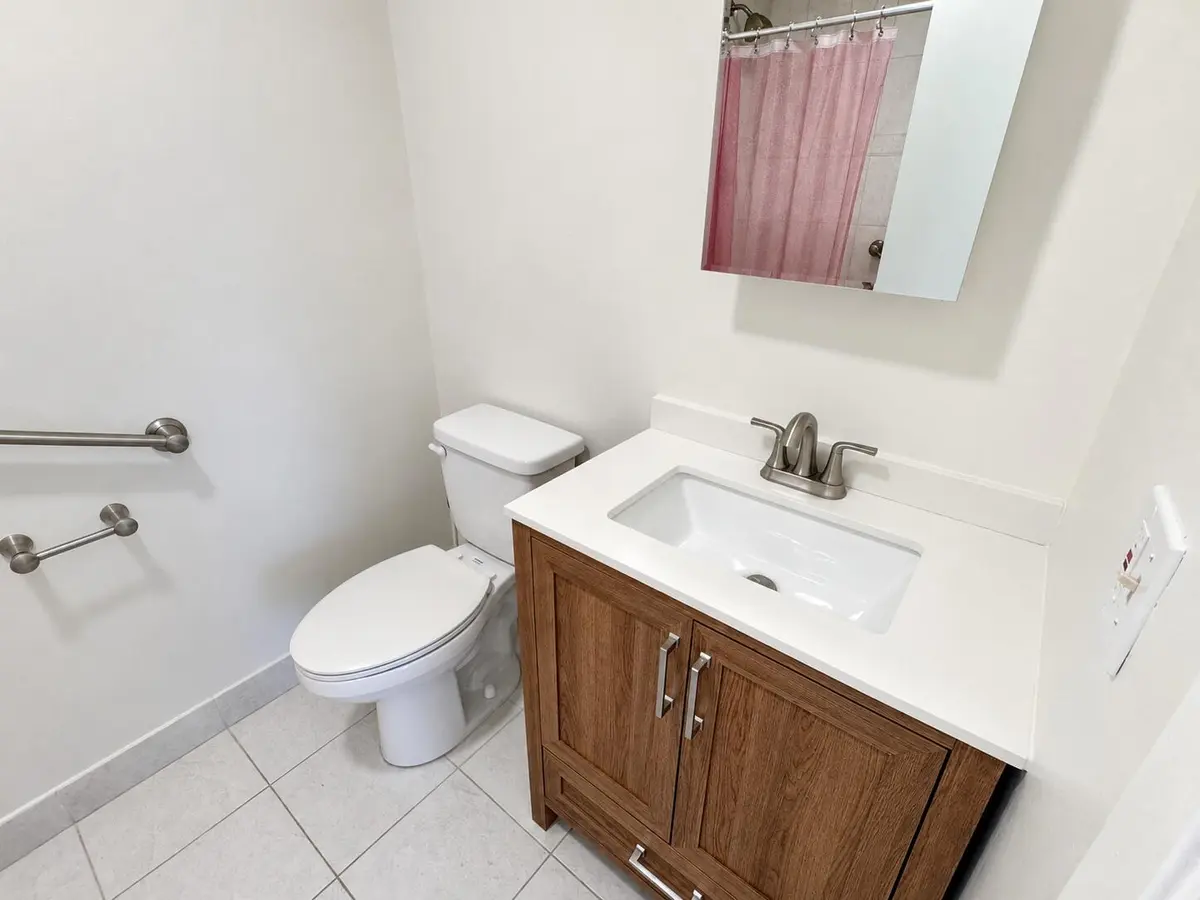 Bright Modern Bathroom with Oak Vanity at 1120 LEMON TREE Terrace 73-C, Delray Beach