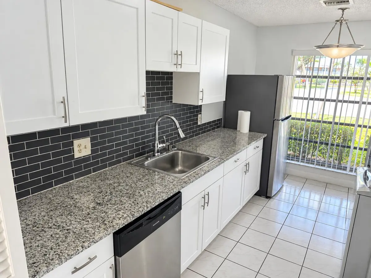 Bright Modern Galley Kitchen with Window at 1120 LEMON TREE Terrace 73-C, Delray Beach